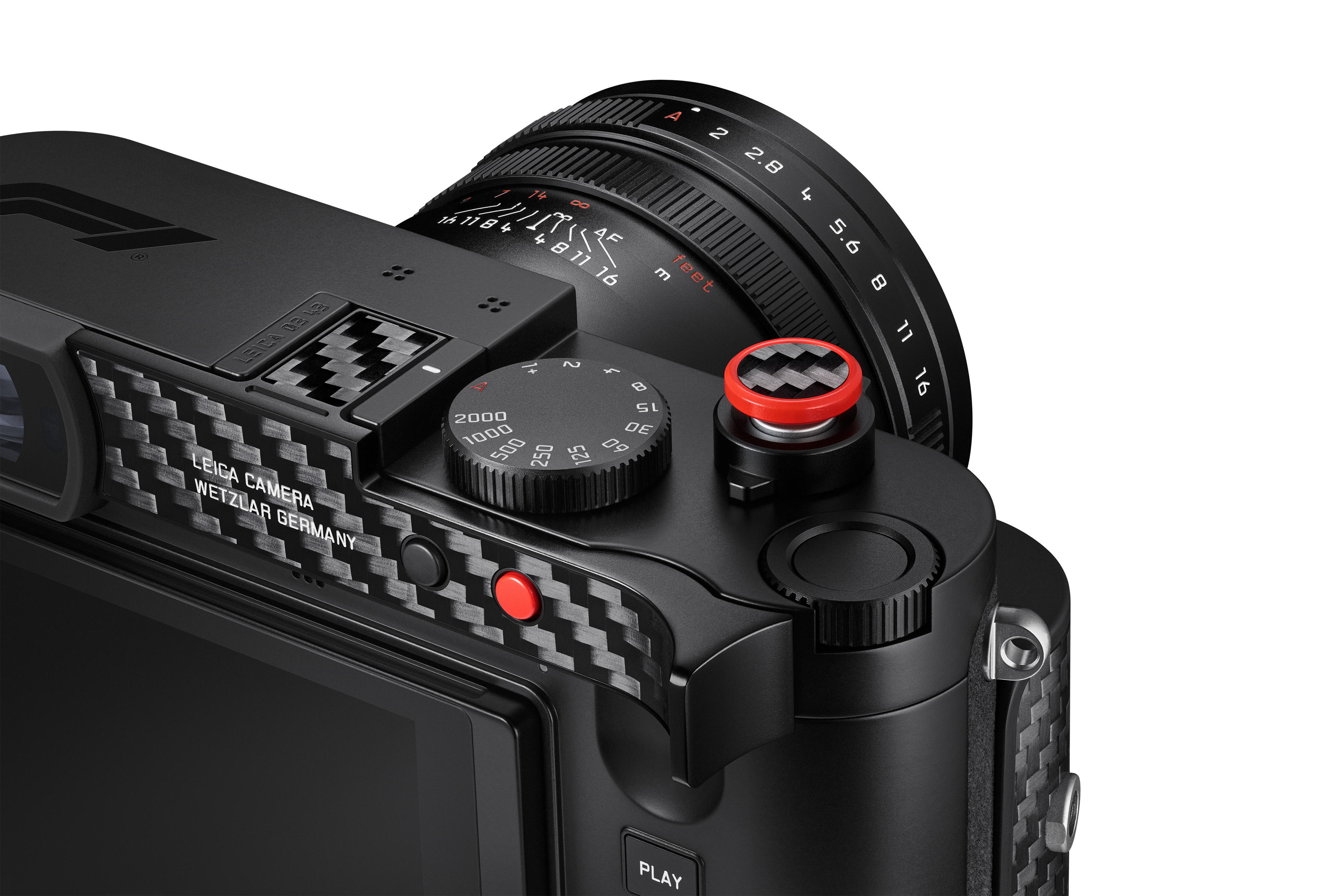 Detailaufnahme der Leica Q3 43 F1 mit Carbon-Oberfläche, rotem Auslöser, Verschlusszeitenrad und hochwertigem Objektiv.