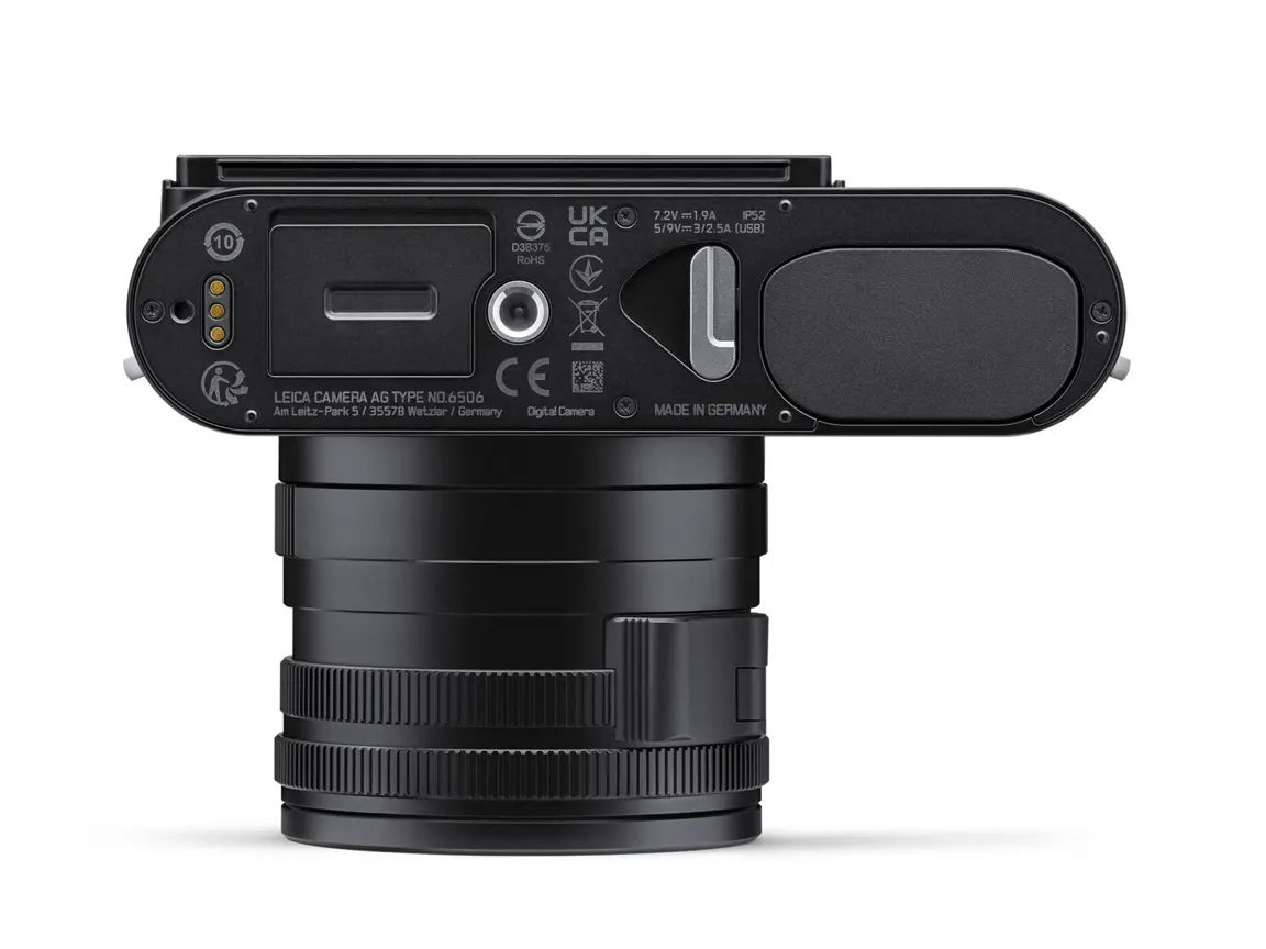 Leica Q3 von unten mit fest verbautem Objektiv, Akku- und Speicherkartenfach sowie Stativgewinde auf weißem Hintergrund.